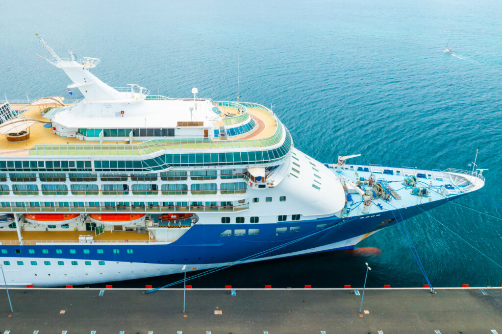 Luftaufnahme eines an der Kaimauer festgemachten Kreuzfahrtschiffs im Hafen mit sichtbaren Decks und Rettungsbooten. Parken Warnemünde Kreuzfahrt